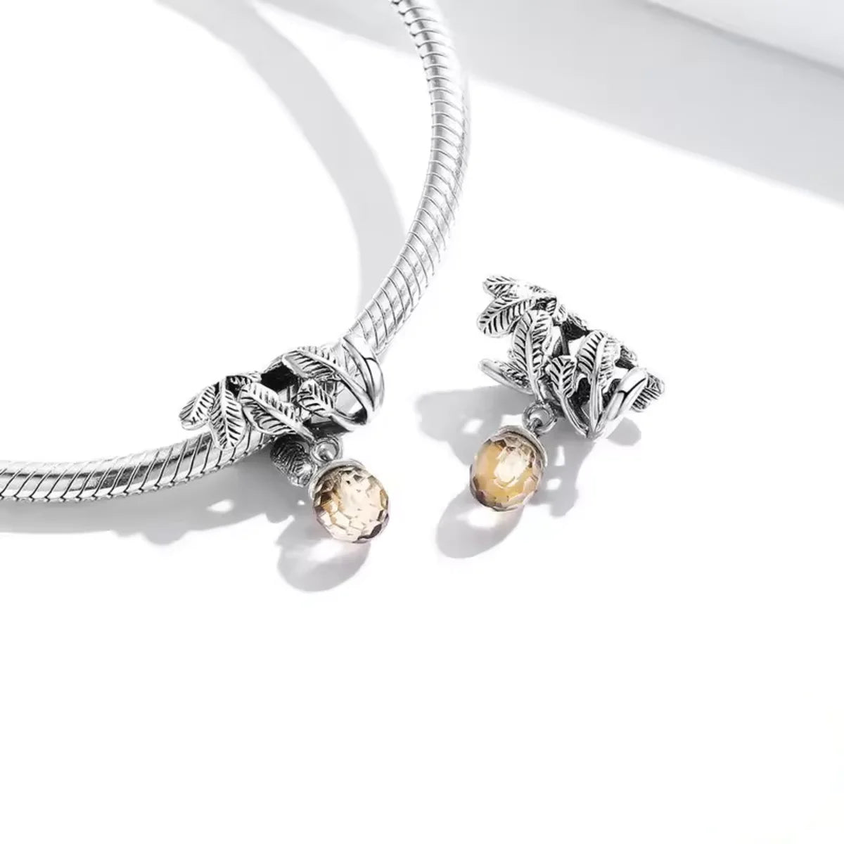 Showcase the beauty of nature with this intricate Acorn and Leaves Charm. Crafted from Sterling Silver, the charm highlights a detailed acorn surrounded by delicate leaf designs. Add this Pandora compatible charm to your collection and express your appreciation for the natural world.