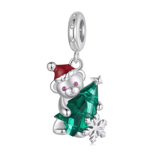 A dangle charm featuring a stylized teddy bear wearing a Santa hat and holding a green bow, with cubic zirconia accents and enamel details.