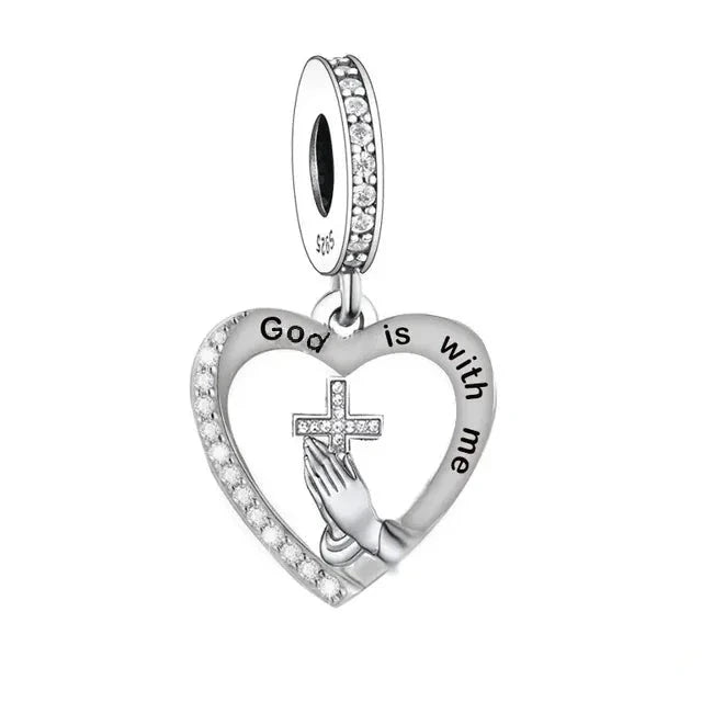 Carry a message of faith and inspiration with this elegant &quot;God Is With Me&quot; Heart Dangle. Featuring a beautiful heart-shaped design adorned with sparkling cubic zirconia, this charm is crafted to bring a touch of grace and motivation to your jewellery collection.