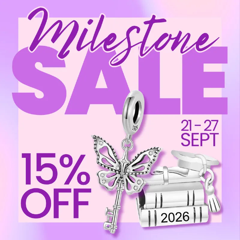 Silver key and book charm pendant displayed on a pink and purple sale graphic with large text reading 'Milestone SALE', '15% OFF', and '21-27 SEPT'.