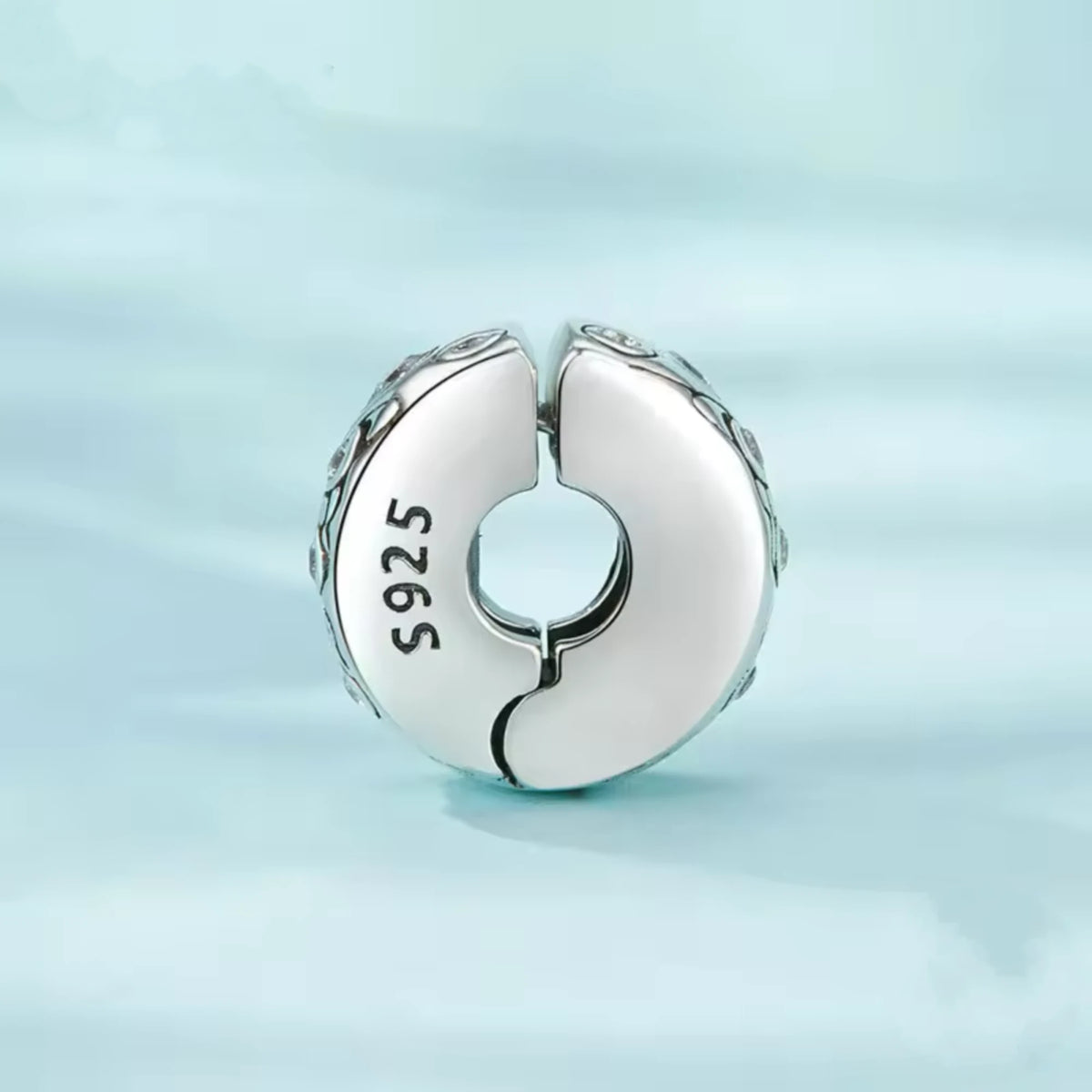 Silver clip charm with butterfly design and embedded cubic zircons on a blue background