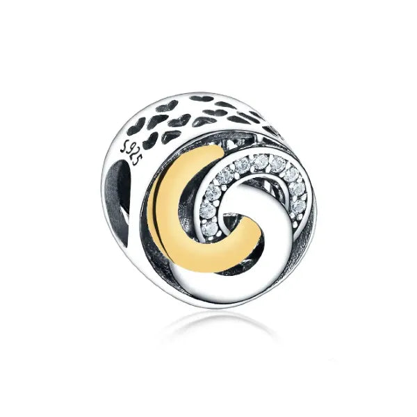 Embrace the beauty of unity and connection with the Trinity Ring Charm. This exquisite design features interlocking circles, symbolizing eternal love and the bond between past, present, and future. Adorned with shimmering cubic zirconia accents and highlighted by a luxurious gold-plated crescent, this charm brings a timeless elegance to your jewellery collection. The sterling silver base, detailed with delicate cut out hearts, ensures it shines brightly on any Pandora-compatible bracelet. Whether you&#39;re cel