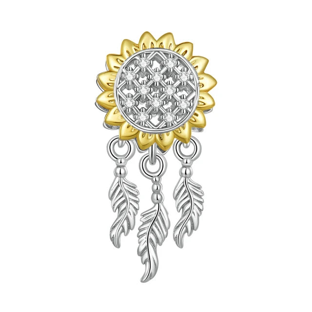 Brighten up your collection with the enchanting Sunflower Dreamcatcher Dangle Charm! This exquisite piece features a beautifully detailed sunflower design, symbolizing happiness and positivity. Adorned with sparkling cubic zirconia and plated in radiant gold.