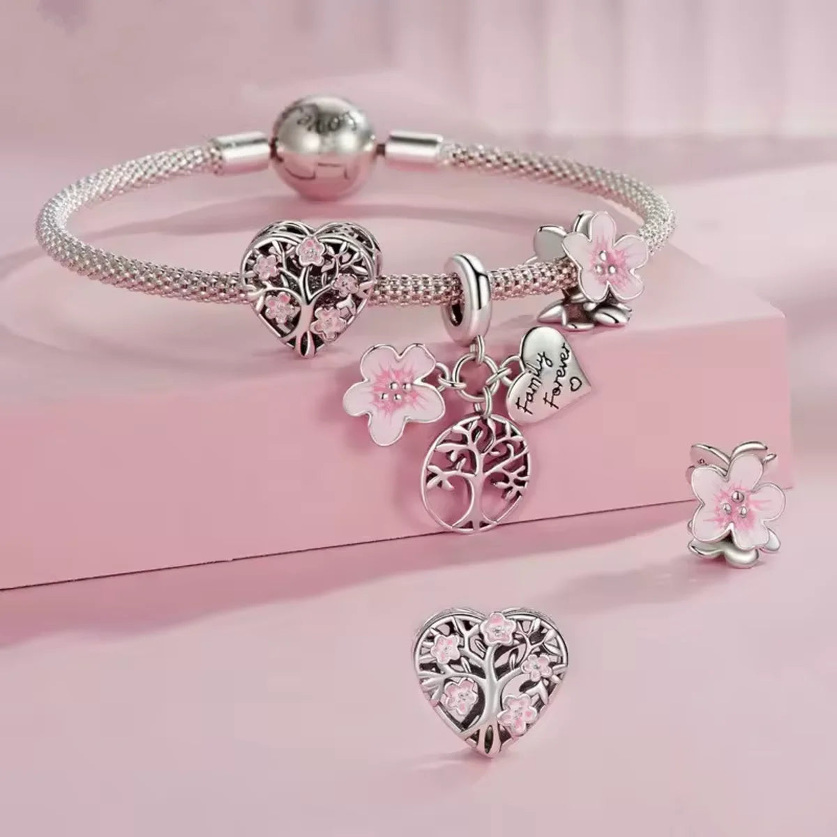 Celebrate unbreakable bonds with the Tree of Life Family Forever Dangle Charm. Featuring a soft pink enamel flower, a loving engraved heart, and a beautifully crafted tree of life, this charm is a touching tribute to the roots and branches that shape who we are.