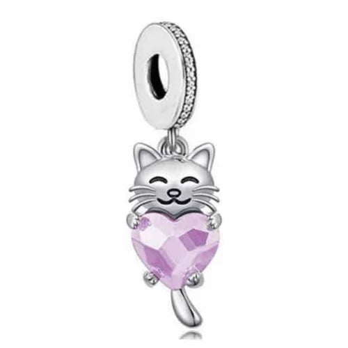 A sterling silver dangle charm in the shape of a cute kitty holding a heart-shaped pink gemstone.