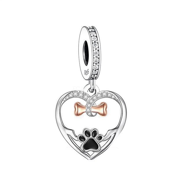 A sterling silver heart-shaped dangle charm with a rose gold bone and cubic zirconia accents.