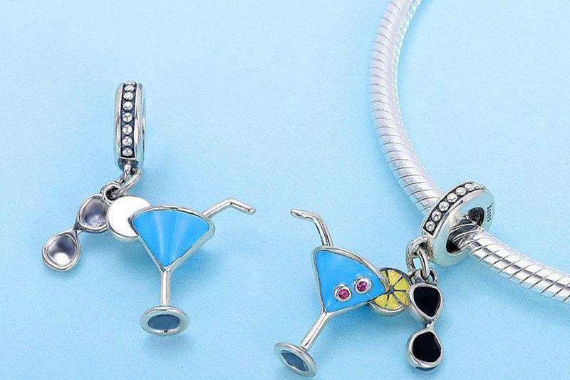 Stay cool this summer with this Summer Cocktail Dangle Charm. Featuring a fun and playful design with colourful enamel accents, this charm is perfect for anyone who loves to relax with a cold drink on a hot day, preferably on an island! Compatible with Pandora bracelets and other popular charm bracelets, this charm is a fun way to celebrate summer.