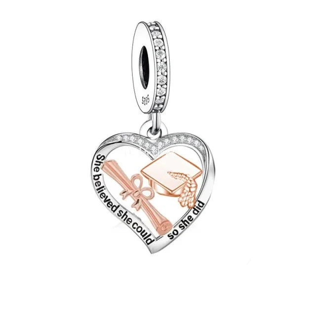 Sterling silver and rose gold plated &quot;She Believed She Could So She Did&quot; graduation dangle charm with CZ accents.